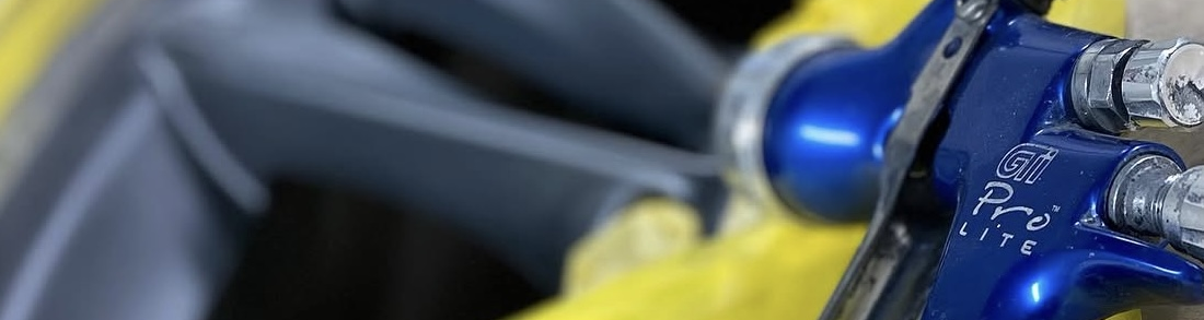 Close-up of a panel being painted during a respray